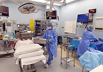 Interior image of two providers in surgical scrubs in a breast surgery operating room