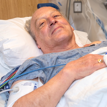 a man in a hospital bed with a blood pressure cuff on his arm