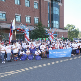 Puerto Rican parade marchers posing with a parade banner and flags