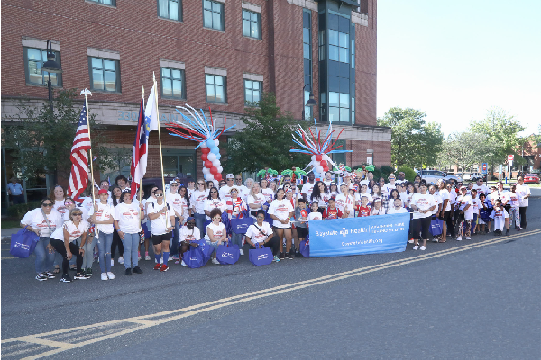 Puerto Rican parade marchers posing with a parade banner and flags
