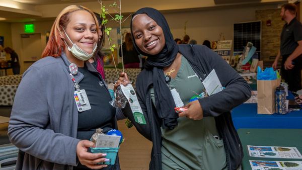 Two Baystate Health employees posing with goodie bag and plant