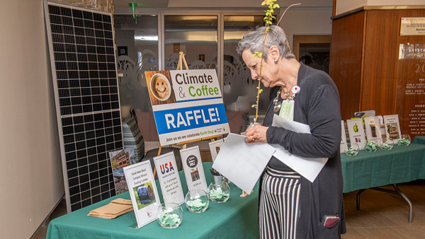 A woman looking at the Climate & Coffee raffle booth