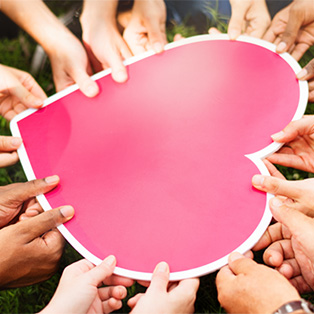 a large carboard shaped heart with many holds holding it