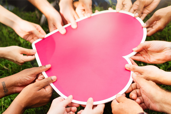 a large carboard shaped heart with many holds holding it