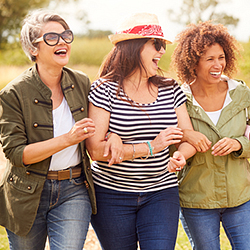 three women walking arm in arm