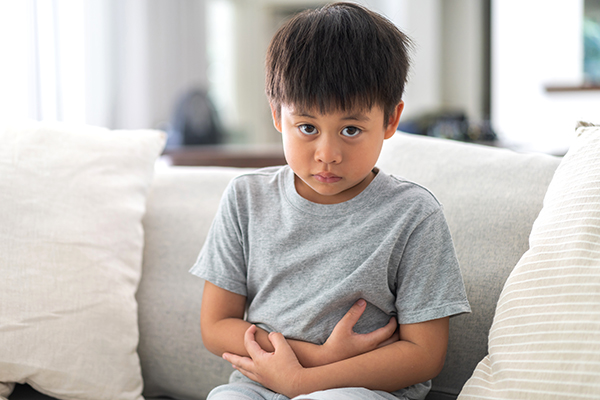 a small child holding their belly with IBS symptoms