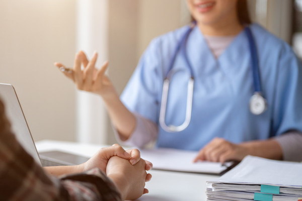 Woman provider speaking with patient while sitting at table.