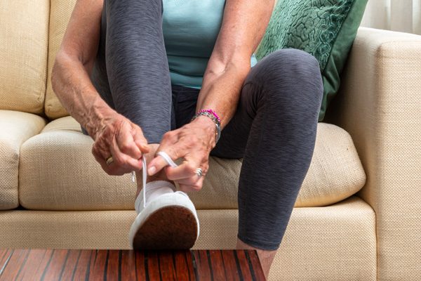 Woman tying her shoes to prevent falling
