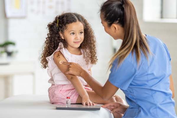 provider putting a bandaid on a little girl's arm