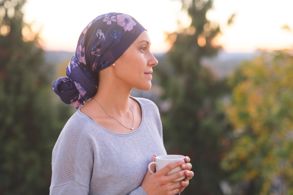 a woman holding a mug and looking out at nature