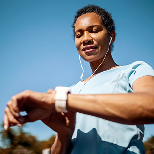 a woman checking her fitness watch for signs of afib