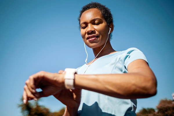 a woman checking her fitness watch for signs of afib