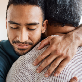 Young African American man hugging his elderly father