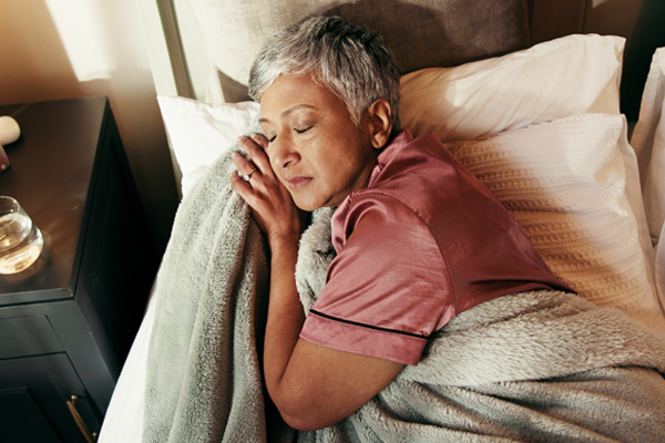 an older woman sleeping in bed