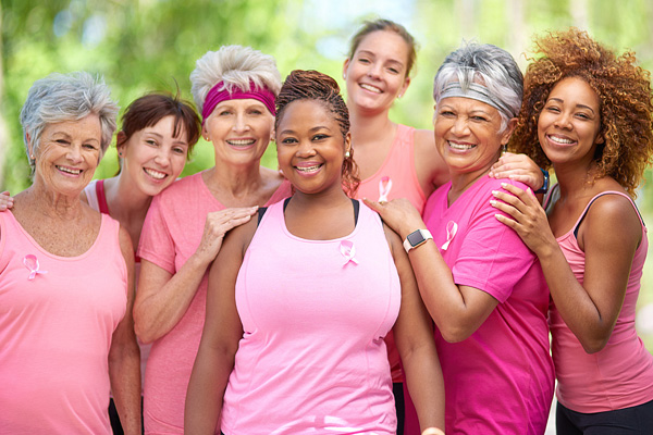 women of various ages, races, and body types, all wearing shades of pink for Breast Cancer Awareness Month