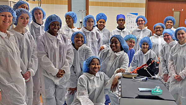 Posed group photo of BSEP students in a lab wearing protective gear