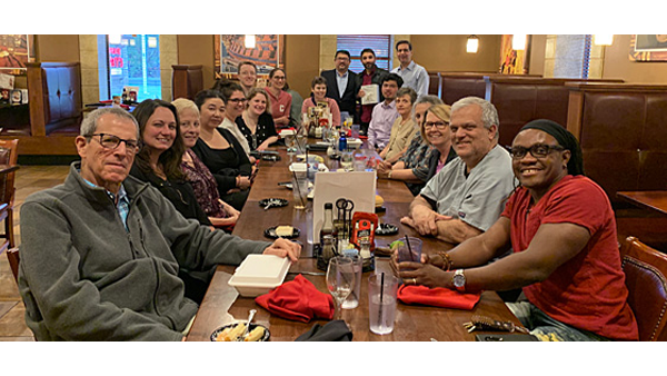 Candid photo of infection disease photos sitting and smiling at a restaurant
