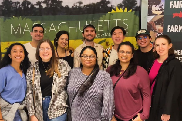 ten internal medicine residents posing in front of a massachusetts banner