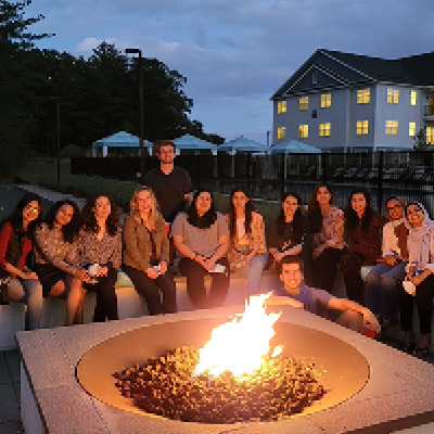 internal medicine residents sitting around a fire at a wellness retreat