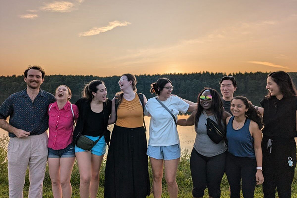 nine internal medicine residents laughing and smiling in front of a sunset
