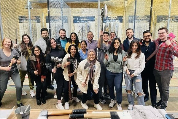 a large group of internal medicine residents at an axe throwing retreat