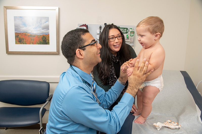 doctor with baby patient with mom looking on