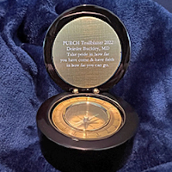 a golden compass opened with an engraving on the top