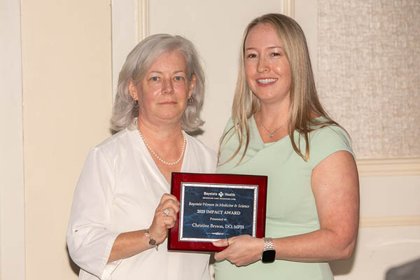 two women holding the bwims impact award