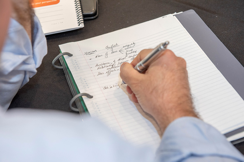 close up of a hand writing in a notepad