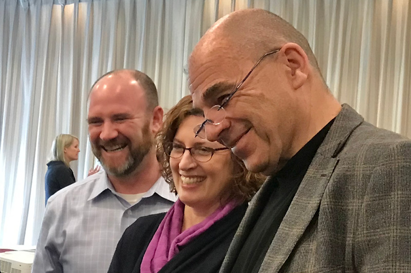 three individuals smiling at a professional development conference