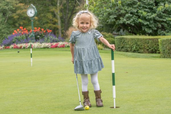 Children's Miracle Network Ambassador for Baystate Childlren's Hospital Emilia Checcetelli hold a golf club and stands with a pin at Longmeadow Country Club.