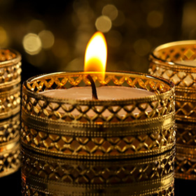 Three gold candles lit in the dark
