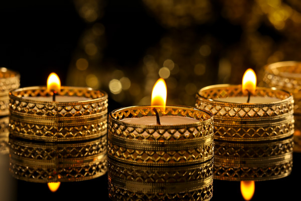 Three gold candles lit in the dark