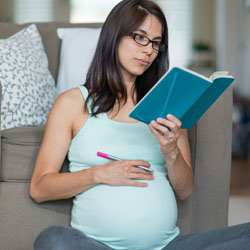 a pregnant woman reading a book