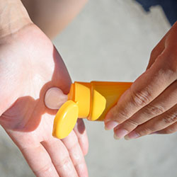 close up of sunscreen being applied in the palm of hand