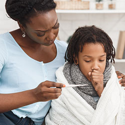 mother showing thermometer to coughing child 