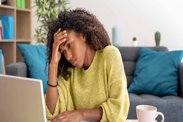 a woman with her hand on her hand looking in pain from a headache