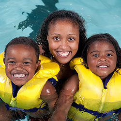 family swimming with life jackets