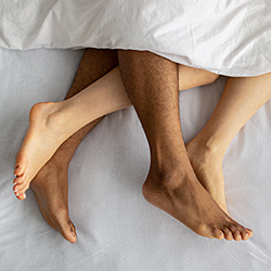Couple's feet under sheets