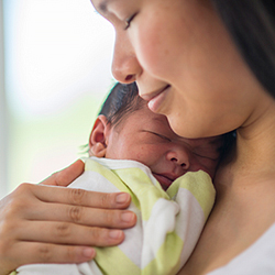 Birthing parent holding newborn who rests on chest