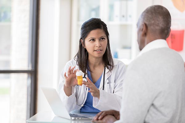 A doctor speaking to her patient about medications for Parkinson's disease