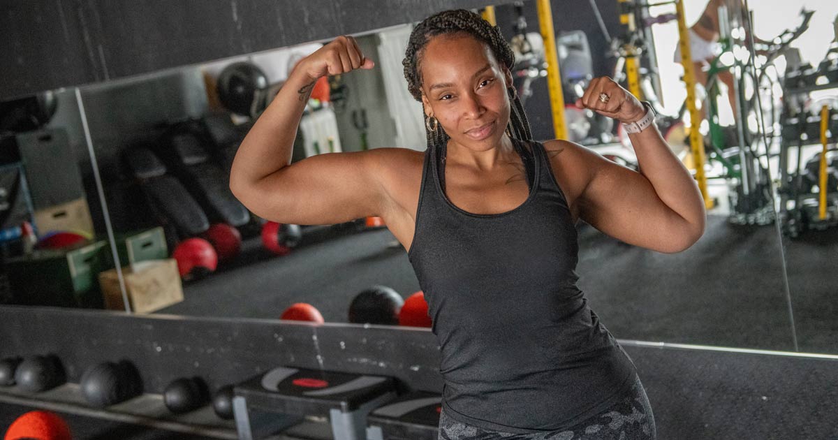 a Black woman in workout gear at the gym showing off her physique