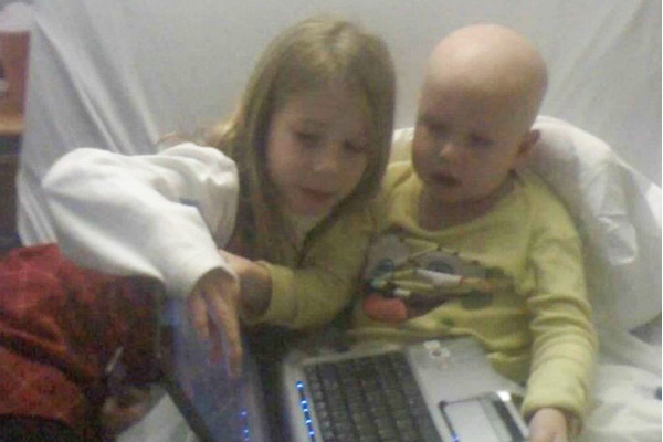 two children playing with a laptop