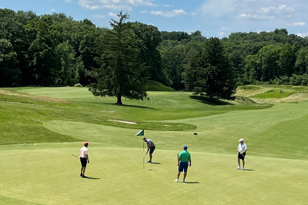 golfers on the putting green of a golf course