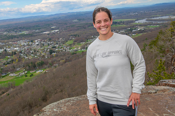 a trauma survivor standing atop a mountain with a beautiful view of the area below