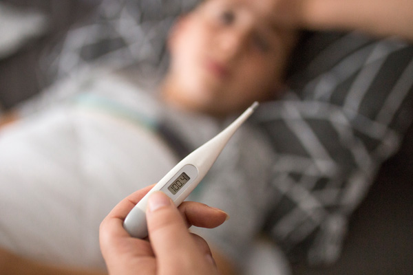 Mother checking her sick sons temperature