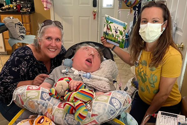 a child with cerebral palsy and quadriplegia with two female adults
