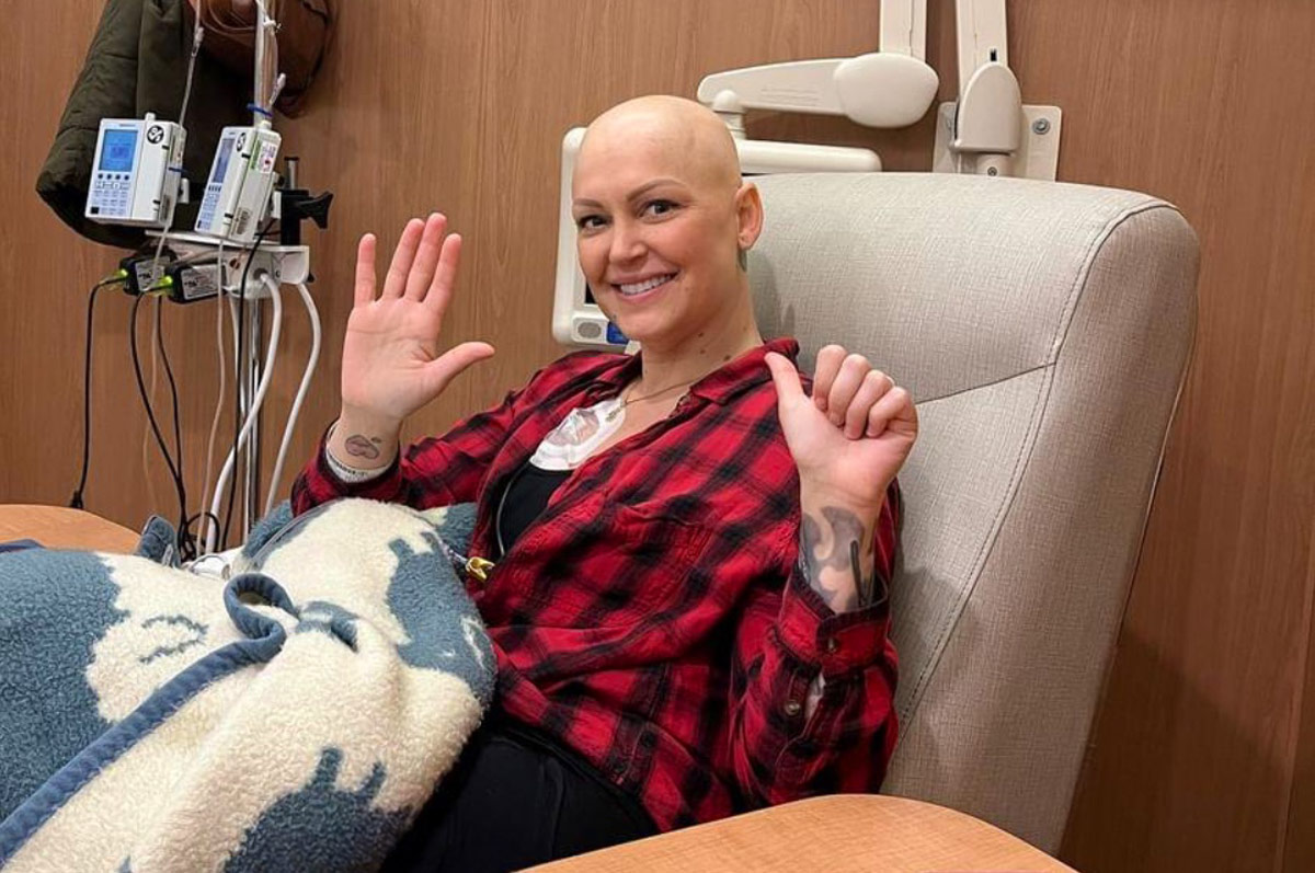 Jenn holding up six fingers while taking her sixth and last round of chemotherapy