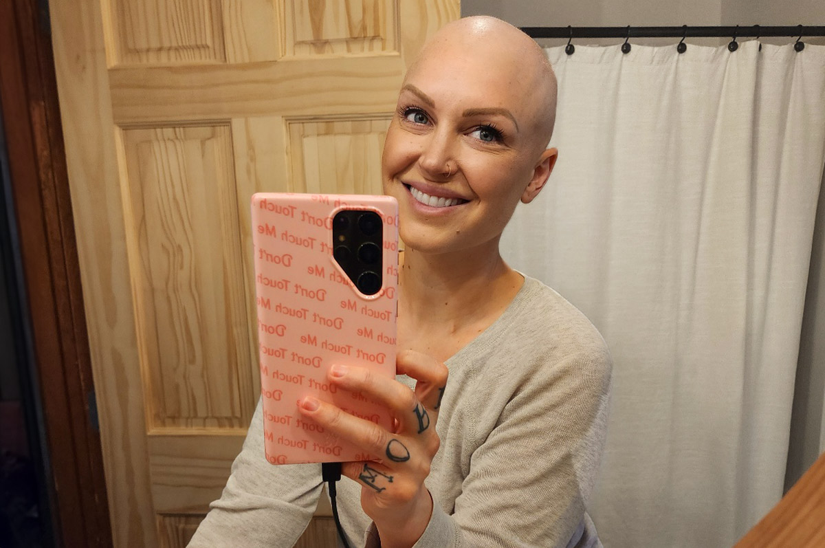 Jenn Venn smiling and taking a bathroom selfie after hair loss