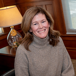 Shannon Schultz smiling while sitting next to lamp